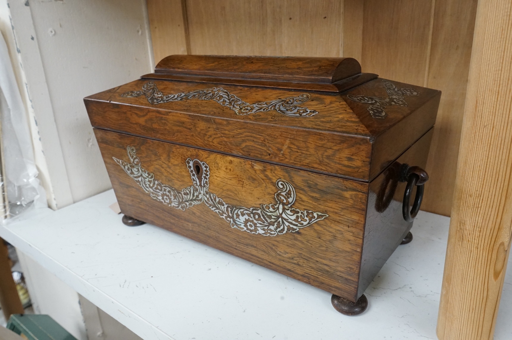 A Victorian rosewood sarcophagus tea caddy with mother of pearl inlay, 36cm wide
